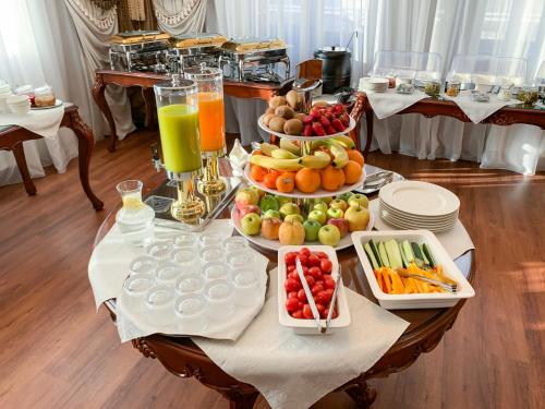 einen Tisch mit Obst und Gemüse und Getränken darauf in der Unterkunft GREGORY Boutique Hotel Chisinau in Chişinău