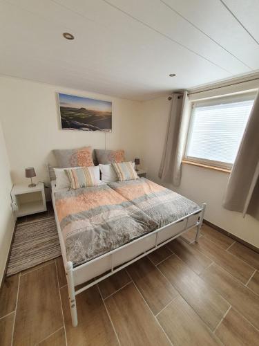 a bedroom with a bed in a room with a window at Ferienhaus Helmig in Kurort Gohrisch