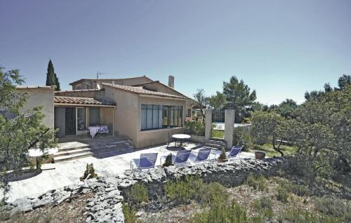 a house with chairs and a table in a yard at Awesome Home In Joucas With Kitchen in Joucas