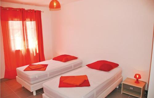 2 bedden in een kamer met rode kussens bij Gorgeous Home In Saint Thome With Outdoor Swimming Pool in Saint-Thomé