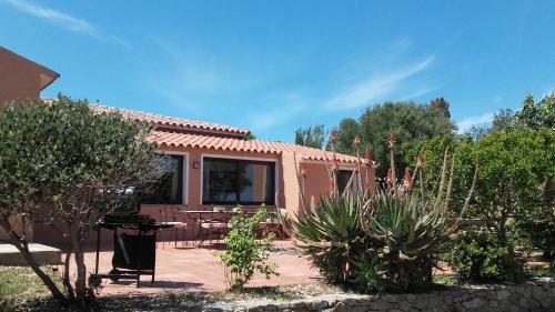 une maison avec une terrasse et des plantes devant elle dans l'établissement Casa GiovanMarco con vista mare, à Santa Teresa Gallura