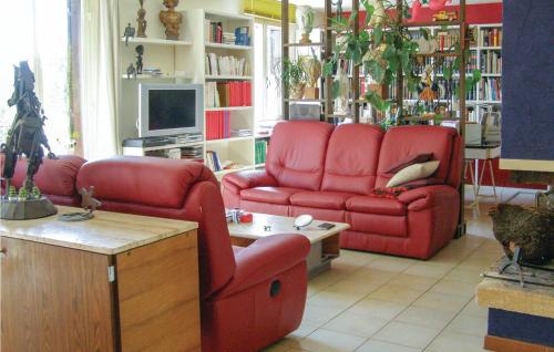 - un salon avec deux canapés rouges et une télévision dans l'établissement Lovely Home In Puisserguier With Wifi, à Puisserguier
