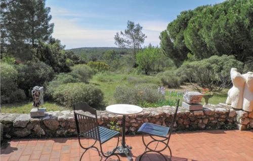 PuisserguierにあるLovely Home In Puisserguier With Wifiの石壁のパティオ(テーブル、椅子付)