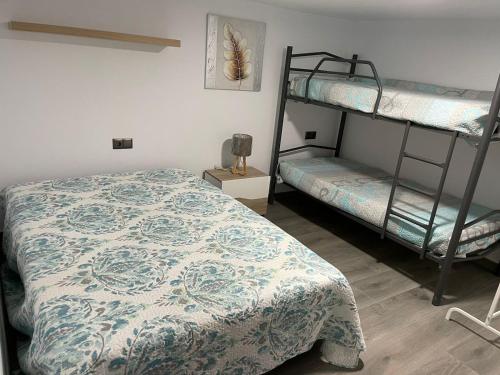a bedroom with two bunk beds and a bedspread at MONTE AZUL in Málaga
