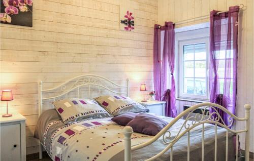 1 dormitorio con cama blanca y pared de madera en Awesome Home In Vergoncey With Kitchen, en La Croix-Avranchin