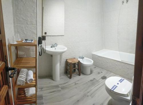 a bathroom with a sink and a toilet and a tub at Hotel El Mirador in Alhaurín el Grande