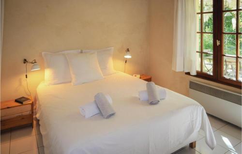 Un dormitorio con una cama blanca con toallas. en Stunning Home In Le Pot-laval With Private Swimming Pool, Can Be Inside Or Outside, en Le Poët-Laval