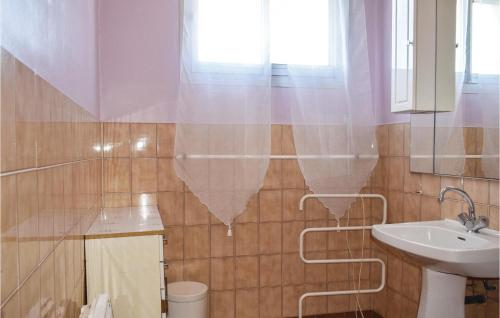 a bathroom with a sink and a toilet and a mirror at Holiday Home Kerguigniou in Kermeur
