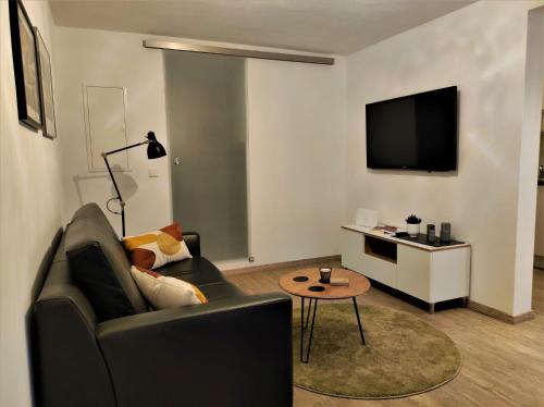 a living room with a couch and a tv at Ferienwohnung Im Stiffje in Schalkenmehren