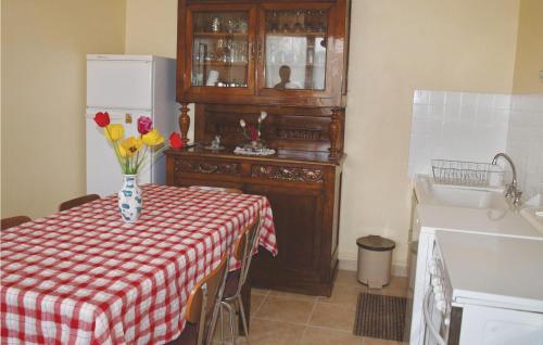 a kitchen with a table with a vase of flowers on it at Holiday Home Kermoisan in Caouënnec