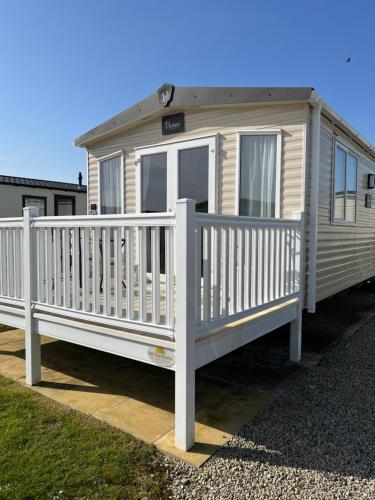 una casa móvil blanca con una valla blanca en Bude holiday home, en Bude