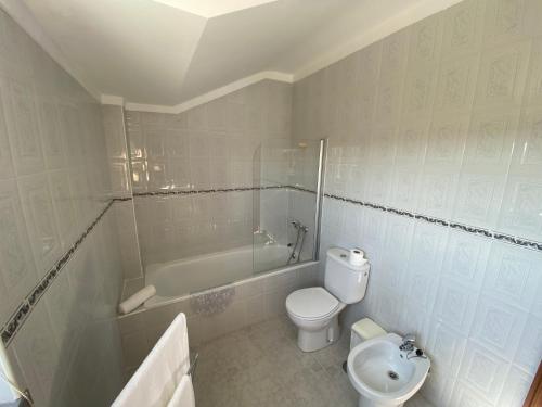 um banheiro com vaso sanitário, banheira e pia em Ericeira Sand Beach R6 na Ericeira
