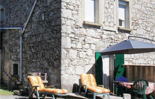 - un groupe de chaises et un parasol à côté d'un bâtiment dans l'établissement 1 Bedroom Nice Apartment In La Beaume, à Labeaume