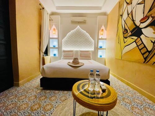 a hotel room with a bed and a table with bottles on it at Maison Chafia Boutique Hôtel & Spa in Marrakesh