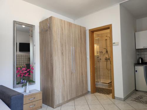 a large wooden cabinet in a room with a bathroom at Studio Sonja in Piran