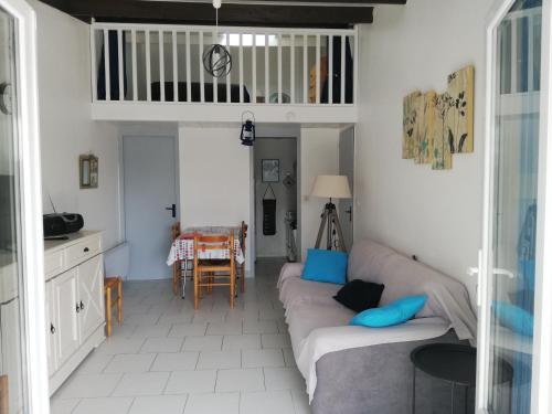 a living room with two couches and a table at Maison à 100 m de la plage à St Hilaire de Riez in Saint-Hilaire-de-Riez
