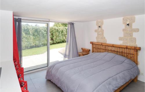 a bedroom with a bed and a large window at Stunning Home In Sernhac With Swimming Pool in Sernhac