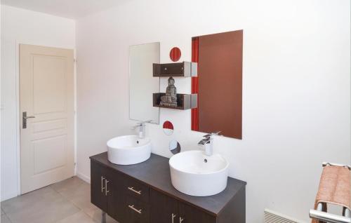 a bathroom with two sinks and a mirror at Stunning Home In Sernhac With Swimming Pool in Sernhac