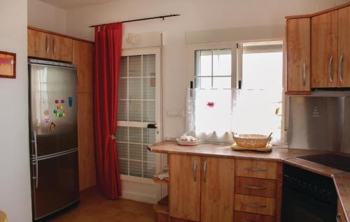 a kitchen with wooden cabinets and a black refrigerator at Holiday Home Monnegre 08 in Monnegre de Arriba