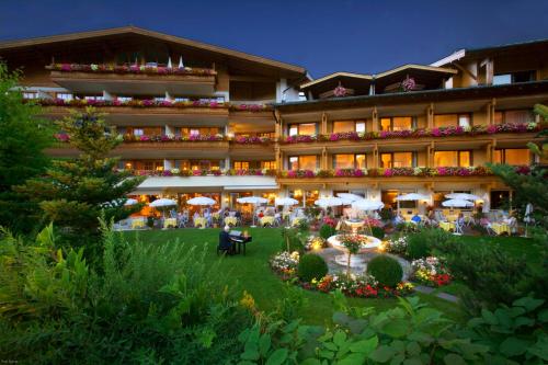a hotel with a garden in front of it at Salzburgerhof Wellness-, Golf- und Genießerhotel in Zell am See