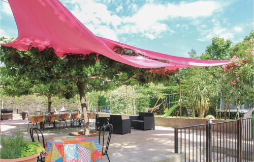 un auvent rose sur une terrasse avec des tables et des chaises dans l'établissement Lovely Home In Châteaurenard, à Châteaurenard
