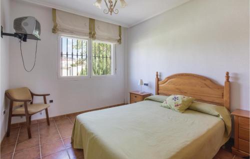 a bedroom with a bed and a chair and a window at Awesome Home In Caravaca With Kitchen in Caravaca de la Cruz