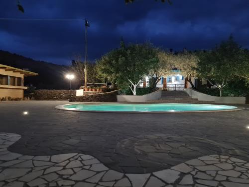 a circular pool in a courtyard at night at Turismo Rurale Filieri in Dorgali