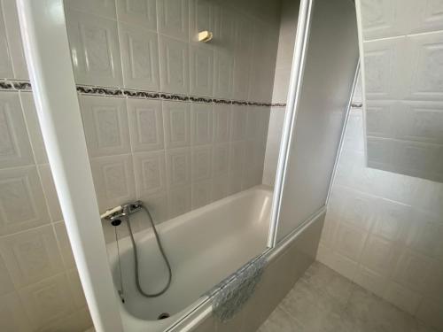 ein weißes Badezimmer mit Badewanne und Dusche in der Unterkunft Ericeira Sand Beach RCT in Ericeira