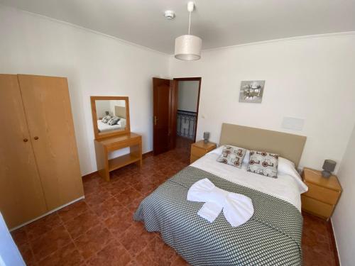 a bedroom with a bed with a white bow on it at Ericeira Sand Beach RCT in Ericeira