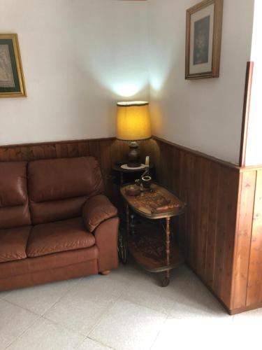 a living room with a couch and a table with a lamp at Soleli in Molino San Biagio