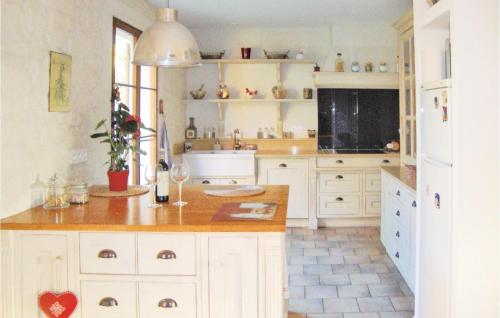 Una cocina con gabinetes blancos y encimera. en La Maoure, en Robion en Luberon
