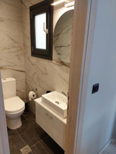 a bathroom with a toilet and a sink and a mirror at ELITE LUXURY APARTMENTS in Argostoli