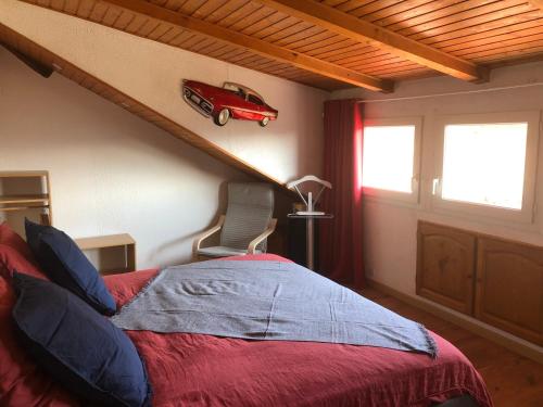 1 dormitorio con 1 cama con un coche rojo en la pared en La maison bleue en Altenbach