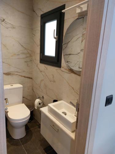 a bathroom with a toilet and a sink and a mirror at ELITE LUXURY APARTMENTS in Argostoli