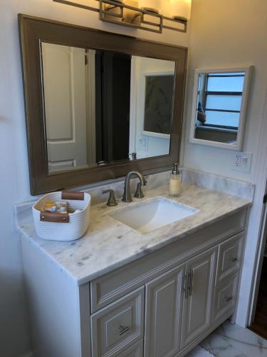 a bathroom with a sink and a large mirror at Cheerful 3 Bed house in a Cul- de-sac! in Tampa