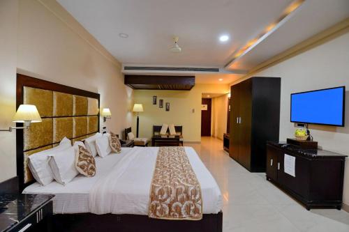 pokój hotelowy z dużym łóżkiem i telewizorem z płaskim ekranem w obiekcie Hotel Floret Inn w mieście Bhilai