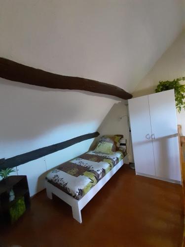 a bedroom with a bed and a white cabinet at Gîte * Gaïa * in Châtel-Montagne