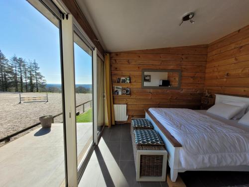 a bedroom with a bed and a view of the beach at Le Cottage de la Doucette in Paimpont