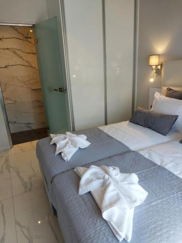 a bedroom with two beds with towels on them at ELITE LUXURY APARTMENTS in Argostoli