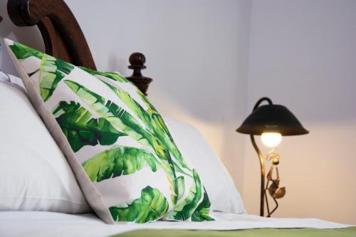 a bed with a green and white pillow and a lamp at Inca's Room in La Paz