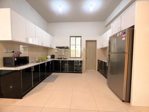 a kitchen with white cabinets and a stainless steel refrigerator at Maison life 小居屋 The Loft Imago in Kota Kinabalu