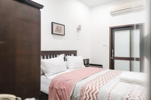 a bedroom with a large bed with white pillows at Pasola Guest House in Medan