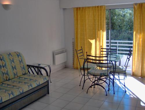 een woonkamer met een bank en een tafel en stoelen bij Palais Rouaze AVA1014-1P in Cannes