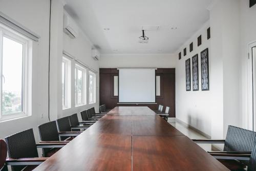 a large conference room with a long table and chairs at Pasola Guest House in Medan