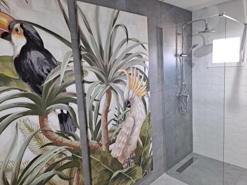 y baño con ducha y una pintura de aves. en LEVANTE SUITES en Benidorm