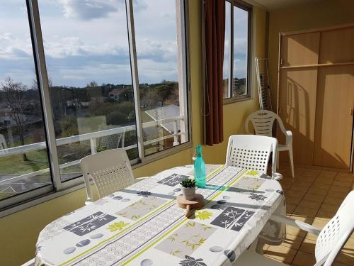 a table and chairs in a room with a window at Cap d'Agde Antinea, Plage Rochelongue, Piscine et Parking in Cap d'Agde