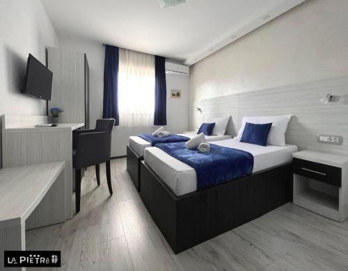 Habitación de hotel con cama y escritorio en La Pietra Family Hotel en Međugorje