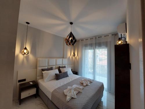 a bedroom with a large white bed with a large window at ELITE LUXURY APARTMENTS in Argostoli