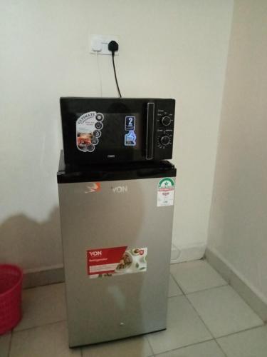 a microwave sitting on top of a refrigerator at Georgia Furnished Apartments in Machakos