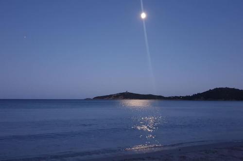 a moon rising over the water with a beach at L'Original, Superbe appartement à 5min de la plage in Zonza